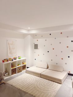 a living room with white furniture and polka dot wallpaper on the walls is shown