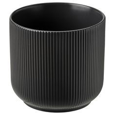 a black vase is sitting on a white surface and it looks like pleated material