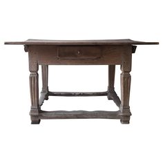 an old wooden table with one drawer on the top and two legs at the bottom