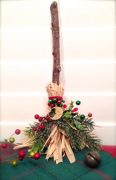 a wooden stick with christmas decorations on it next to a pile of balls and branches