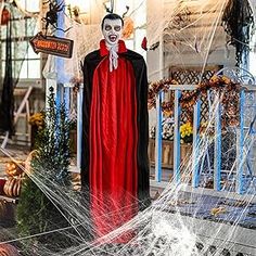 a halloween display in front of a building with spider webs on the ground and decorations around it