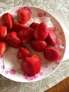 a white plate topped with lots of strawberries on top of a doily covered table