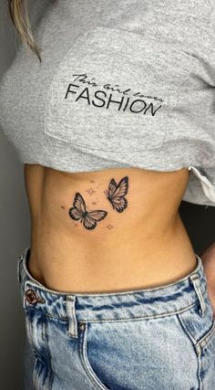 a woman's stomach with two butterflies on her side and the words fashion written in black ink