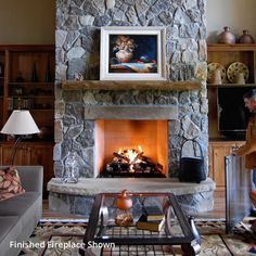 a living room filled with furniture and a fire place in front of a stone fireplace