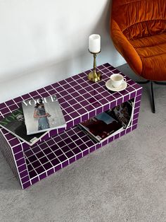 a coffee table with magazines on it next to a chair