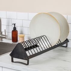 a kitchen counter with plates and soap dispenser