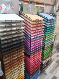 many different colored folders stacked on top of each other in front of a wall