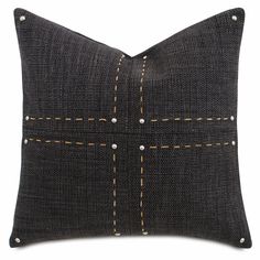 a black pillow with yellow stitching on it