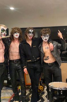 the band kiss posing for a photo with their faces painted like they are wearing white and black