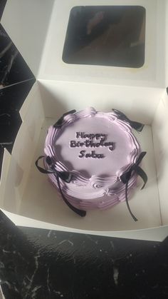 a pink birthday cake in a white box