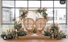 a decorated stage set up with chairs and flowers in front of a large window overlooking the city