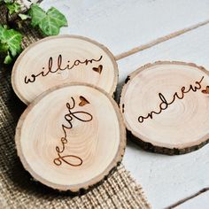 three personalized wood slices with the names of their loved ones on them are sitting next to each other