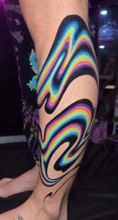 a woman's legs with colorful tattoos on them