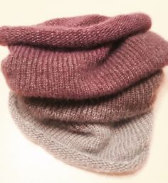 three different colored knitted hats sitting on top of each other