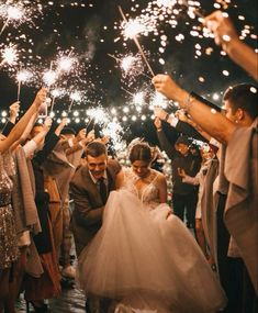 the bride and groom are surrounded by sparklers