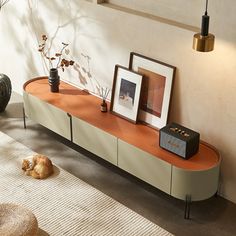 a living room with an orange shelf and pictures on the wall