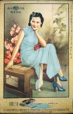 a woman sitting on top of a wooden table next to a flower vase with flowers in it