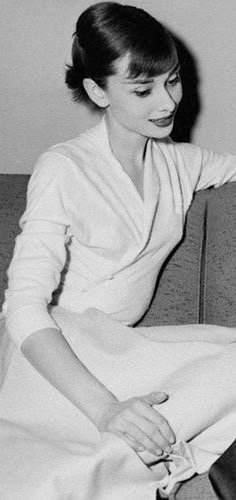 a black and white photo of a woman sitting on a couch