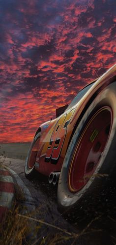 the front tire of a racing car on a track at sunset with clouds in the background