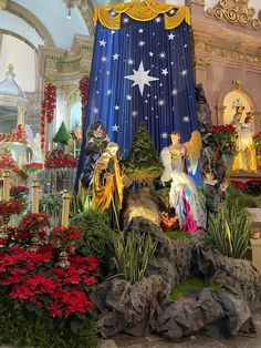 a christmas display in the middle of a room filled with flowers and decorations on top of rocks