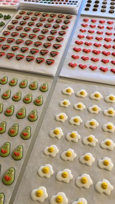 several trays filled with different kinds of eggs on top of baking sheet covered in icing