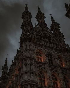 an old building with many windows and spires on it's sides at night