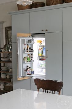 an open refrigerator in a kitchen next to a table