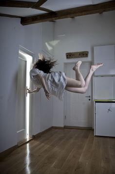 a woman is jumping in the air with her legs spread out