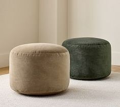 two round stools sitting on top of a rug in front of a white wall