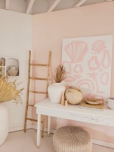 a white table topped with vases next to a painting on the wall in a room