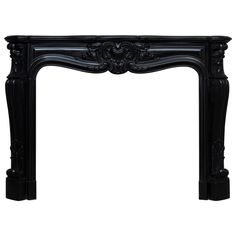 an ornate black fireplace mantel with carvings on the top and sides, in front of a white background