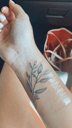 a woman's arm with a small flower tattoo on the left side of her wrist