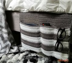 there is a crocheted bag with sunglasses on it next to the bedding