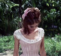 a woman in a pink dress walking down the street