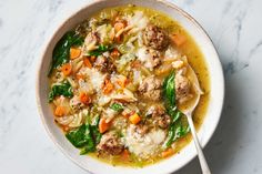 a white bowl filled with meat and vegetable soup on top of a marble countertop