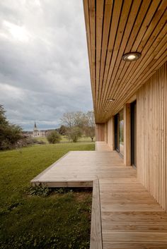 the wooden porch is next to an open grassy field