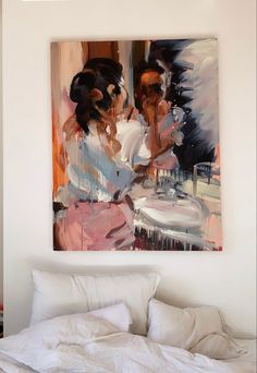 a painting hanging on the wall above a bed in a room with white sheets and pillows