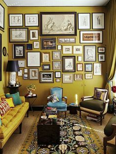 a living room filled with yellow furniture and pictures on the wall above it's coffee table