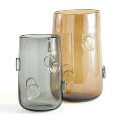 two glass vases sitting next to each other