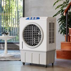 an air conditioner sitting on top of a floor next to a table and stairs