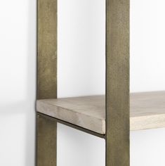 a wooden shelf with metal legs against a white wall