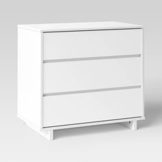 a white dresser sitting on top of a gray floor