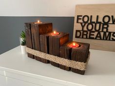 some candles are sitting on a table next to a sign