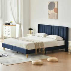 a bedroom with white walls and wooden floors