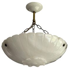 a white bowl shaped light fixture hanging from a chain