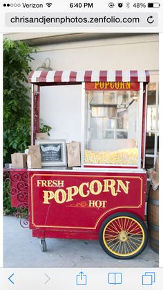 an old fashioned popcorn cart sitting on the sidewalk