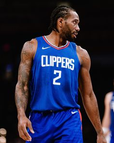 a basketball player wearing a blue uniform and holding a ball