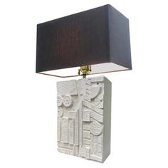 a table lamp with a black shade on it and a white box shaped like a door