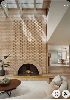 a living room filled with furniture and a fire place in front of a brick wall