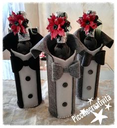 three wine bottles decorated with red flowers and bows